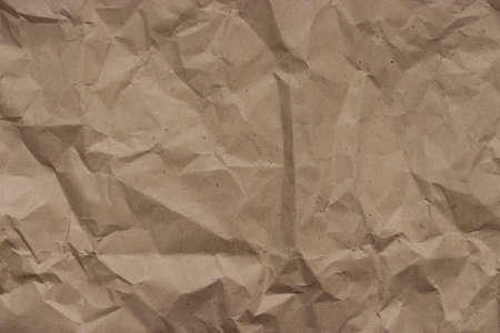 Beige crumpled craft wrapping paper, texture background, wrinkles creases on paperの写真素材