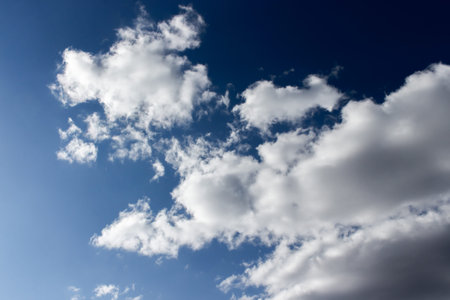 Dark evening sky with white clouds. Twilight blue sky with puffy cumulus clouds, heavenly landscape....