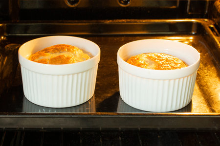 Egg omelette baked in the oven in white tins, two servings of omelette for breakfast, cooking in the ovenの写真素材