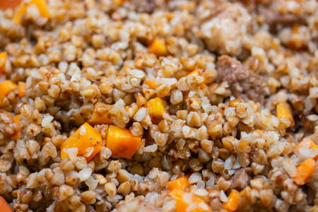 Buckwheat porridge with meat and vegetables, close-up background, traditional Russian food, buckwheat cooked to a clay pot with meat carrots and vegetablesの写真素材