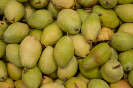 Bartlett pears in a supermarket. A bunch of green ripe juicy natural fresh pear fruits. Background wallpaper backdrop, many pearsの写真素材