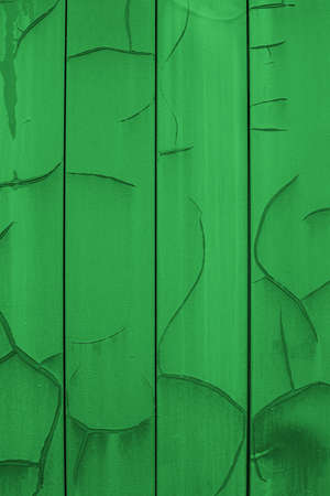 Vertical metal siding painted in bright green with cracks and erosion, old wall sheathing surface, textured effect. Background wallpaper backdrop texture for design. Green painted platesの写真素材