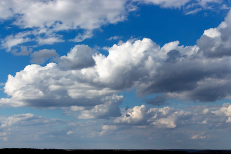 cloudscape and skyline, lush cumulus clouds on bright blue sky, cloudy weather. Beautiful natural...