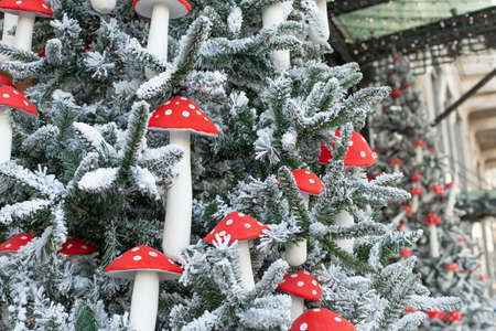 Christmas tree in the snow decorated with festive garlands and fly agarics. New Year decorations on the streetsの写真素材