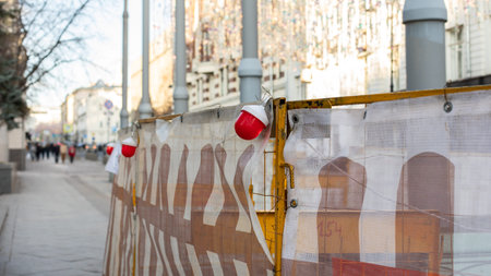 Red lantern and fencing on a city street, construction and repair work on a city street. Repair of communications, restoration of pavement, fencing construction work.の写真素材