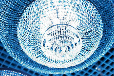 Blue glow, a beautiful crystal chandelier with many glass crystals of diamonds. Background backdrop wallpaper for design. Glass crystal beads reflection light refractionの写真素材
