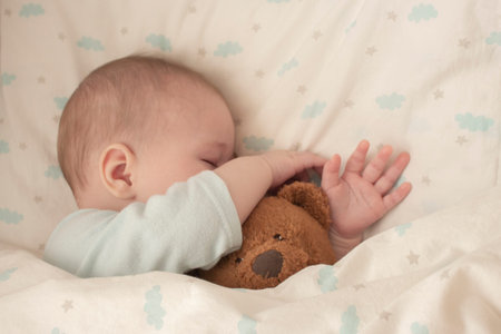 Newborn baby child asleep hugging a bear. Sleeping baby girl boy hid his nose in a teddy bear....