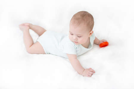 Newborn baby wholly on white bedspread. Little child lying on his stomachの写真素材