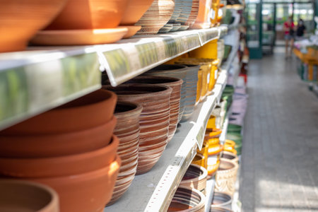 Shelf with empty clay flower pots for sale. Defocus background perspective, brown clay flower pot handmade. Garden accessoriesの写真素材