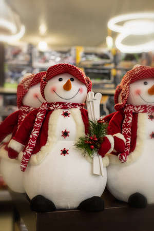 Big cheerful snowman in a red jacket and hat with skis. Christmas decoration puppet snowman. Winter, christmas and new year symbolの写真素材