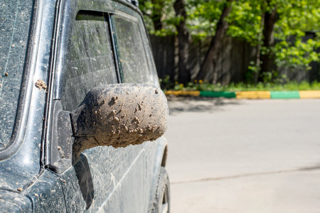 The side mirror of the car is splashed with mud and earth. Off-road vehicle after driving on clay soil, dirty car close-upの写真素材