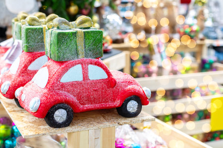 Red toy car with gift on the roof, holiday banner with shining highlights, copy spaceの写真素材
