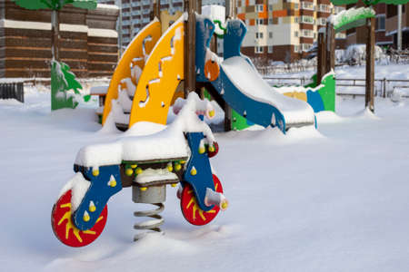 Playground in the snow, wooden rocking motorcycle covered with snow, unexpected large amount of snow in winterの写真素材