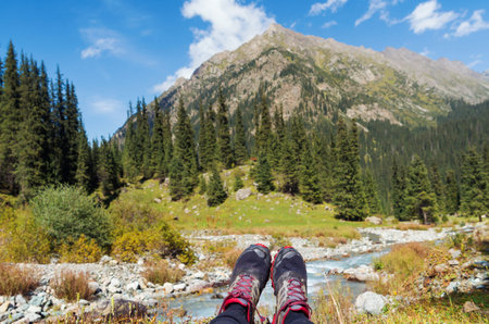 Feet of a person lying on a meadow in the mountains. First person view. Enjoy wild nature and...