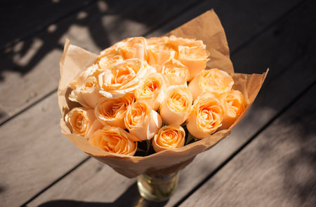orange rose bouquet standing in glass vase outsideの写真素材