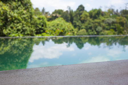 water reflecting green trees and blue sky in poolの写真素材