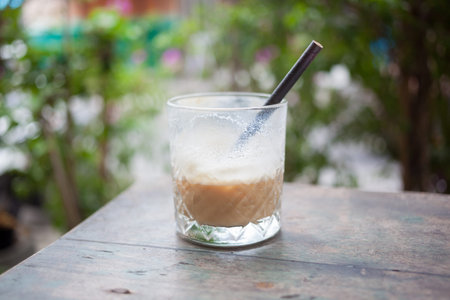 Ice coffee with straw in glass at summer cafe