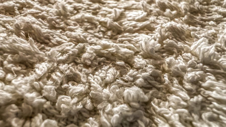 Fluffy texture of warm cozy plaid. Macro terry fabric color beige cream. Carpet texture close-up. Background with terry cloth. Soft focus. Film grain pixel texture.の写真素材