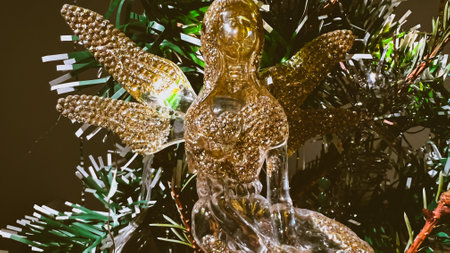 Vintage style Christmas ornament in shape of fairy made from glass and golden glitter. Retro angel on Christmas tree. Xmas decoration. Film grain texture. Soft focus. Blurの写真素材