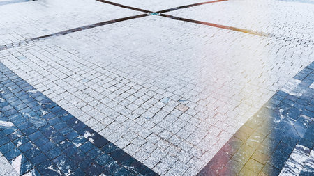 Pavement with tiles color cream beige and black in historic part of city. Urban landscape background...
