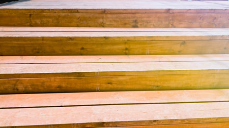 Wooden stairs. Background with geometric lines of ladder steps. Golden yellow toning. Soft focus. film grain pixel texture. Defocused.の写真素材