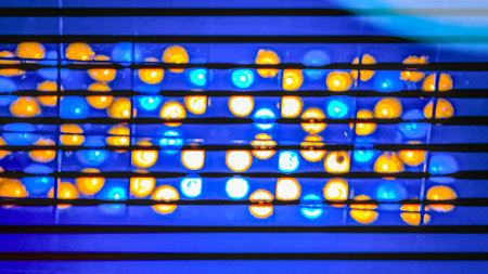 Noen glow of color lamps. LED illumination colors blue yellow orange. Abstract wallpaper with light bulbs. Soft focus. film grain pixel texture. Defocused.の写真素材
