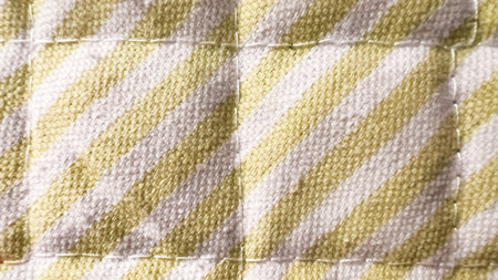 Background of stitched blanket with white green stripes. Wallpaper with macro plaid. COzy vintage abstract backdrop. Kitchen napkin. Soft focus. film grain pixel texture. Defocused.の写真素材