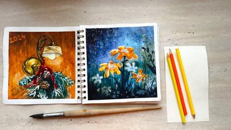 Sketchbook with vivid colorful watercolor illustrations and art tools on table. Aquarelle sketching....