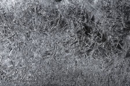 Beautiful white frozen ice crystals, crack texture on black background, winter seasonal backdropの写真素材