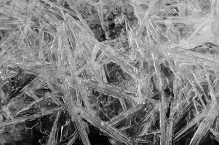 Transparent white frozen ice crystals as crack texture on black background, winter seasonal backdropの写真素材