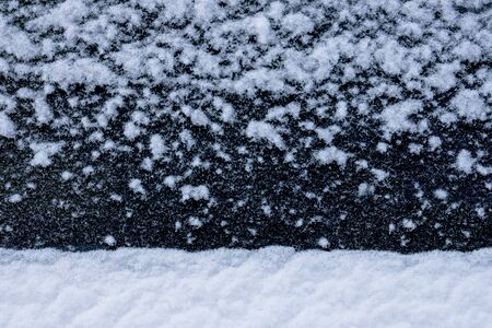 Snow white flakes texture on black background as winter landscapeの写真素材
