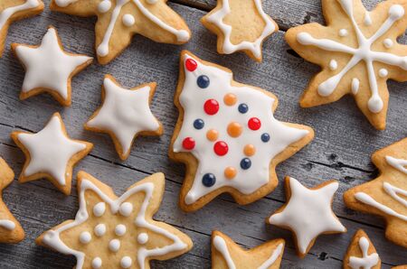 Gingerbread Christmas homemade cookies in form of festive figures on wooden rustic table background, top view, close-upの写真素材