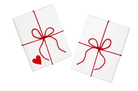 Two wrapped  gift rectangular boxes with red ribbon bow and heart, isolated on white, top viewの写真素材