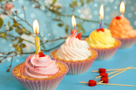 Cake with cream and a birthday candle on a blue blurred background.
