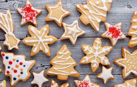 Homemade Christmas star, spruce and snowflake cookies with white frosting on wooden grey background, top viewの写真素材