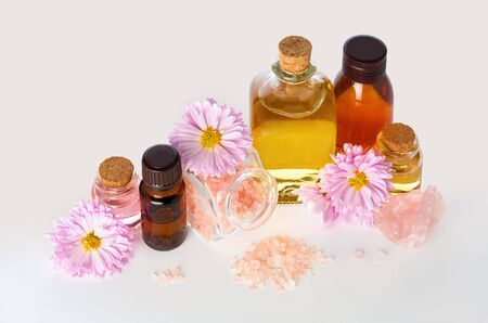 Aromatherapy essential oil in medical glass bottles with chrysanthemum flowers and bath salt for SPA and Wellness on white backgroundの写真素材