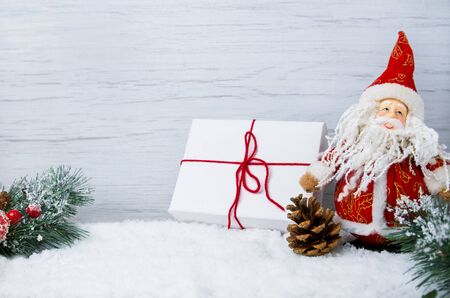Christmas scene with snow, fir branches with cones and Santa Claus toy, copy spaceの写真素材