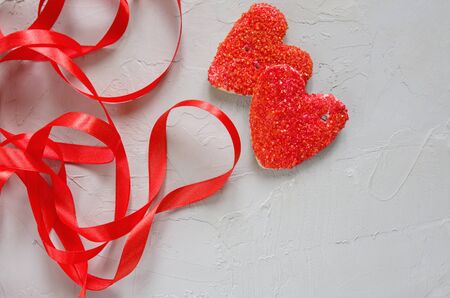 Cookies in the shape of a red heart with a ribbon on a gray background. Valentine's day and romantic, copy spaceの写真素材