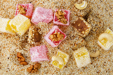 Colorful Turkish delight with coconut sprinkle on sesame seeds background, top viewの写真素材