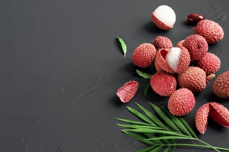 Fresh lychee fruit with leaves on dark background, top view, copy spaceの写真素材