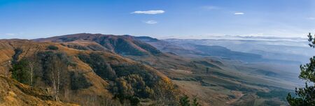 Autumn mountain panorama with blue sky and clouds. The view from the top.の写真素材