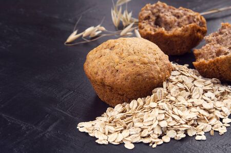 Oatmeal cupcake and oat grain on dark stone table background.の写真素材