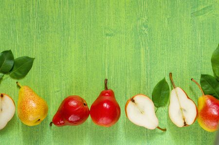 Pears on wooden background.Bright beautiful green background with copy space and red ripe pear fruitの写真素材
