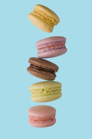 Macaroni almond cakes of different colors on a blue backgroundの写真素材