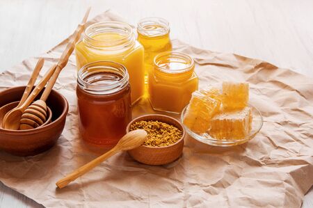 Natural honey in glass jars, honeycomb and pollen on Kraft paper backgroundの写真素材