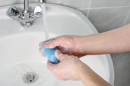 Wash hands with soap and tap water in bathroom as protection against bacteria, flu and dirt for skin...