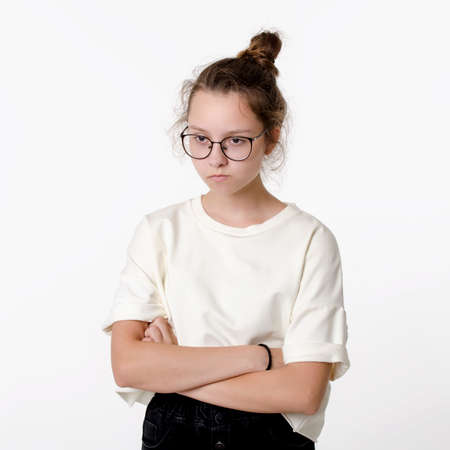 Cute Ñaucasian teen girl with glasses frown and take offense, portrait on white backgroundの写真素材