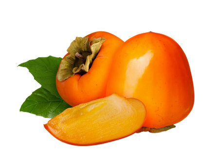 Ripe persimmon fruit with slice and green leaves isolated on white backgroundの写真素材