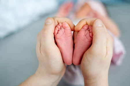 Baby feet in mother hands. Mom and her Child. Happy Family concept. Beautiful conceptual image of...