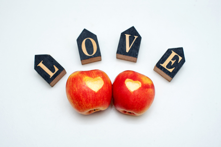 Love of apples concept with a neatly incised heart in the skin of a ripe red apple in St. Valentina's Dayの写真素材
